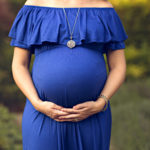 Toronto Prenatal Massage - close up of pregnant belly in blue dress