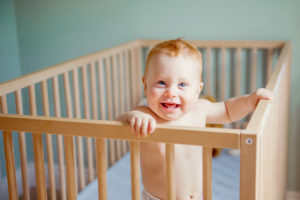 Toronto-baby-photography - red head baby boy standing in crib