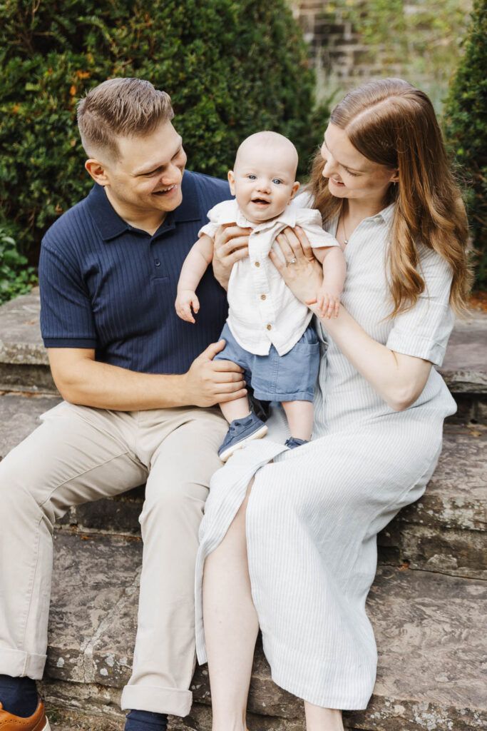 parents and young baby on steps in Toronto Park.