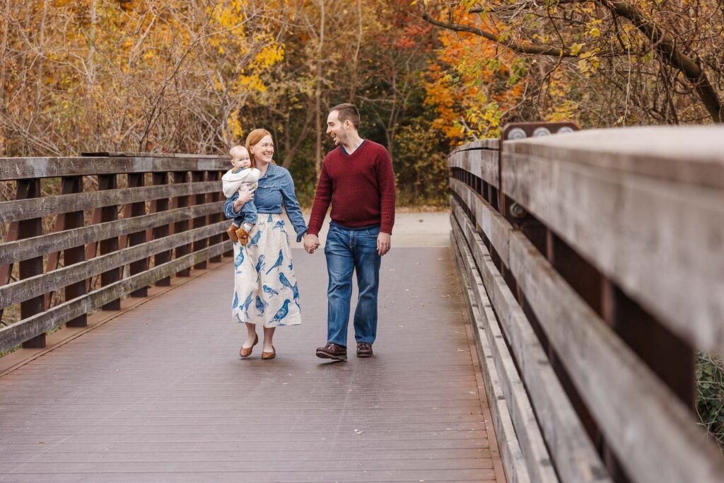 Couple and baby strolling through Toronto Park during the fall. 