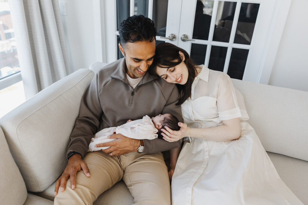 tender moment captured of parents and new daughter during Toronto Newborn photos in their downtown condo