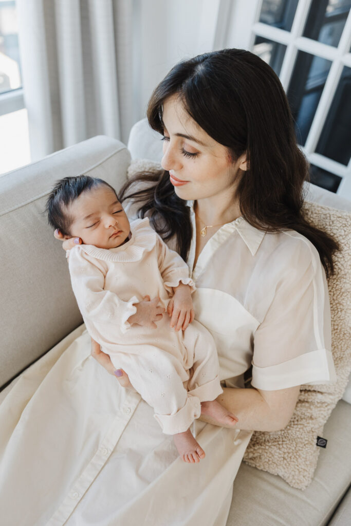 mom admiring new baby girl during downtown toronto condo newborn photo session.