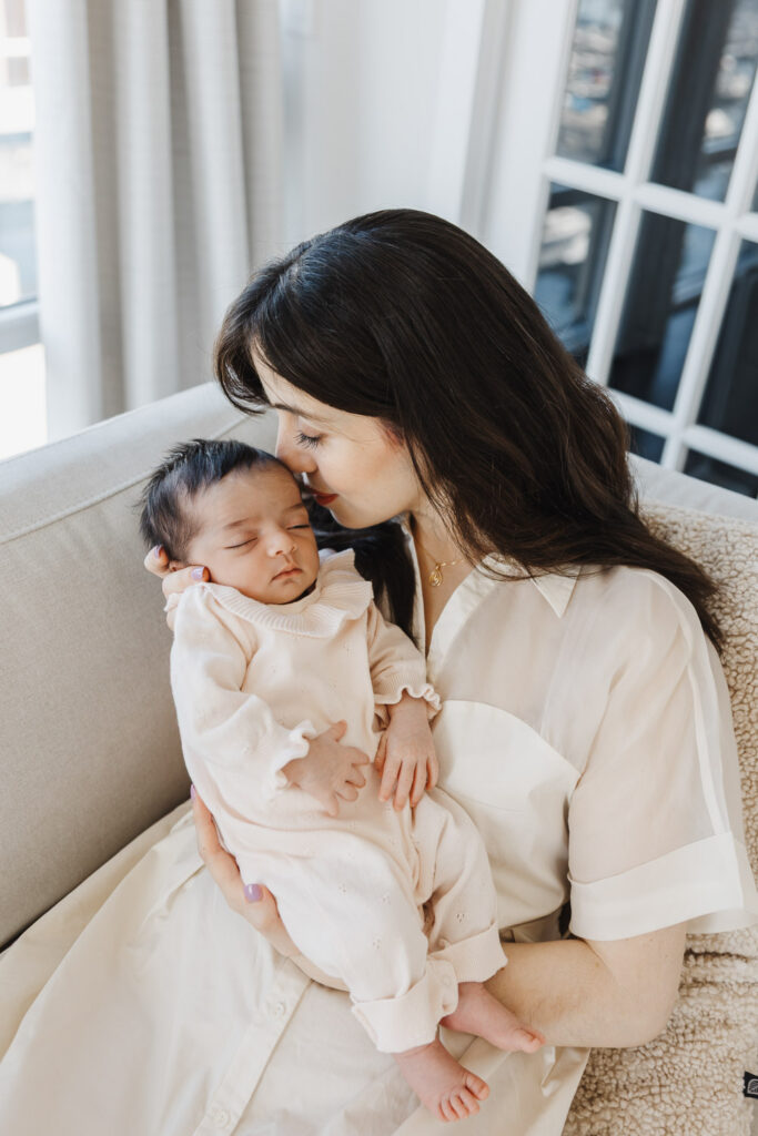 Mom nuzzles newborn baby girl in downtown toronto condo newborn photoshoot