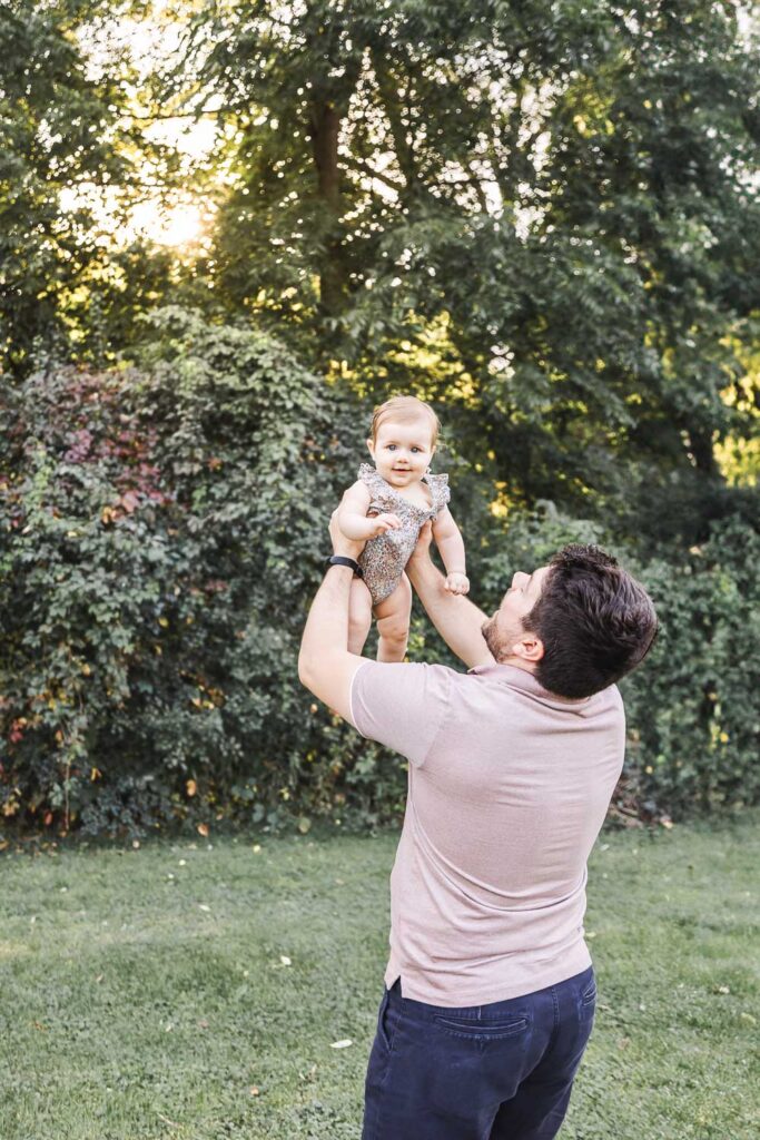 dad lifting up baby girl
