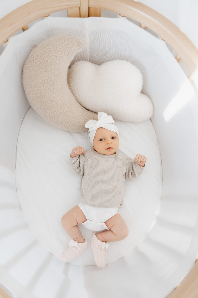 awake baby girl in crib captured by Toronto Newborn Photographer Claire Binks