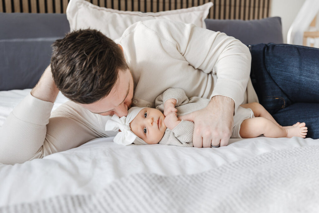Dad cuddling newborn baby during Toronto in-home newborn photo session