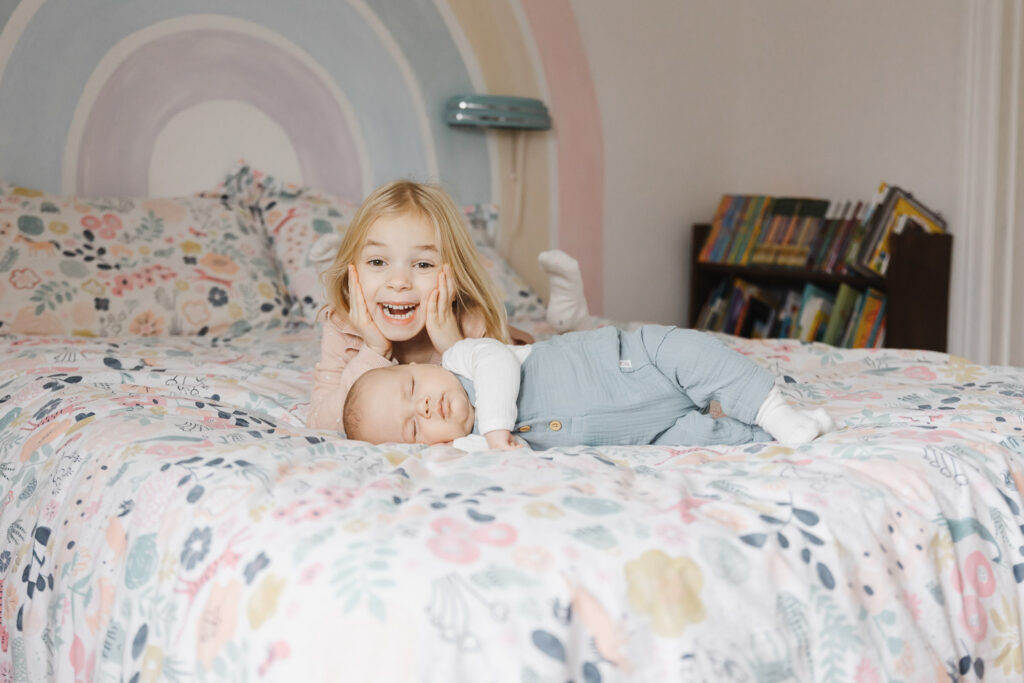 big sister posing with newborn baby brother during toronto at home newborn photo session